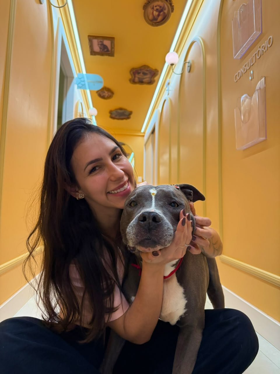 Ketlin Boff sentada ao lado de um cão cinza e branco na Alluvie.